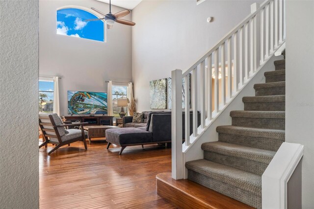 1048 Lake Berkley Dr, Kissimmee, FL 34746 - staircase featuring a wealth of natural light, wood finished floors, ceiling fan, and a towering ceiling