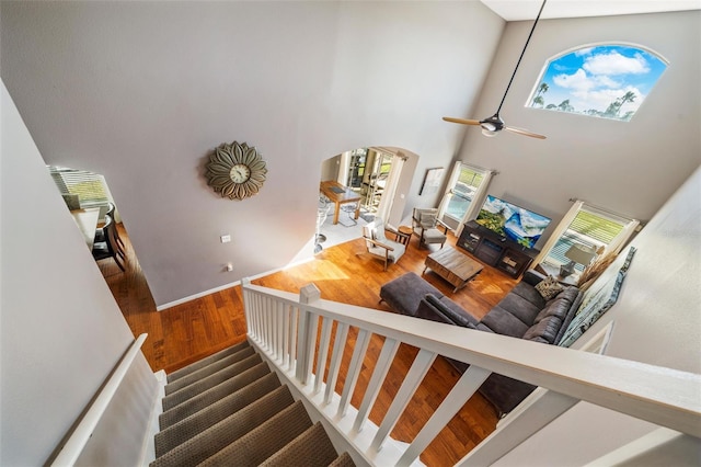 1048 Lake Berkley Dr, Kissimmee, FL 34746 - staircase with a wealth of natural light, a ceiling fan, arched walkways, and wood finished floors