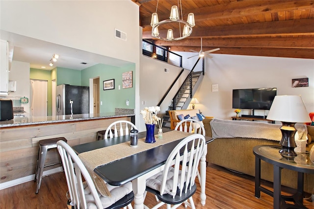 dining room with beamed ceiling, visible vents, wood finished floors, and wooden ceiling