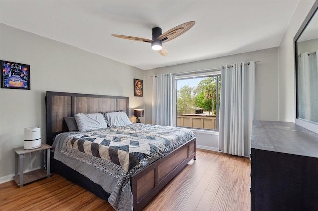 bedroom featuring baseboards, ceiling fan, and light wood-type flooring