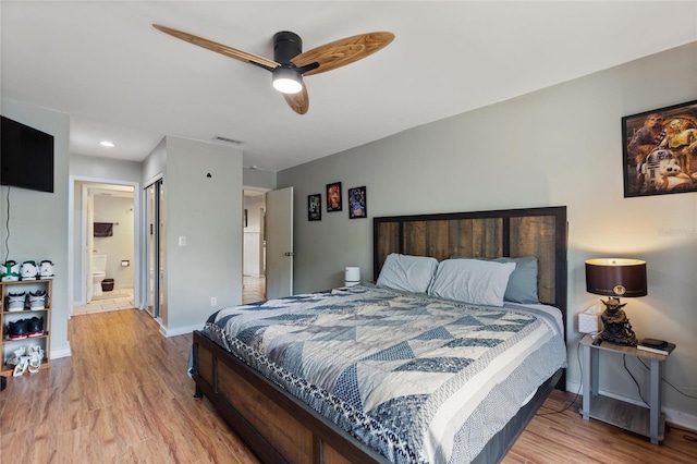 bedroom with ensuite bathroom, baseboards, light wood finished floors, and visible vents