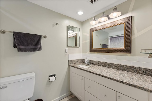 bathroom with baseboards, visible vents, toilet, and vanity
