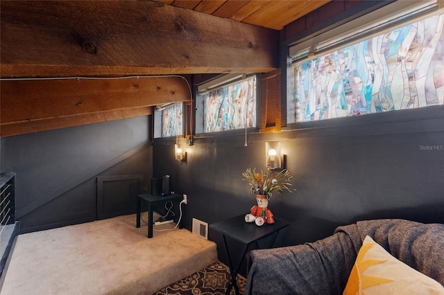 living area featuring visible vents, wooden ceiling, and carpet