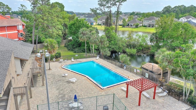 community pool with a residential view, a water view, and fence