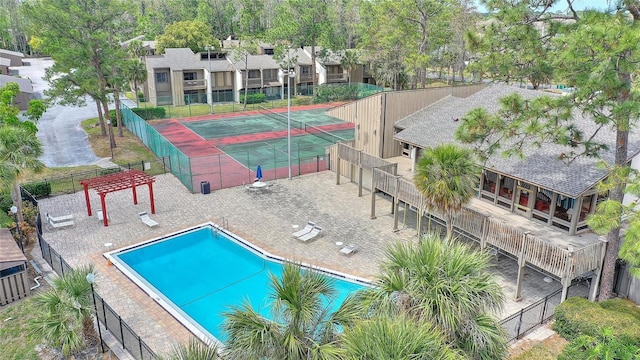 community pool with a tennis court and fence
