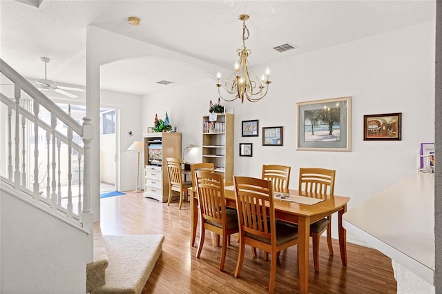 1149 S Beach Cir, Kissimmee, FL 34746 - dining area featuring stairway, arched walkways, visible vents, and light wood-type flooring