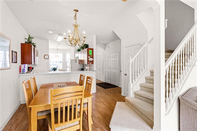 1149 S Beach Cir, Kissimmee, FL 34746 - dining area featuring stairway, baseboards, an inviting chandelier, and wood finished floors