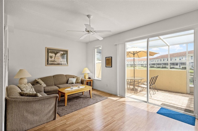 1149 S Beach Cir, Kissimmee, FL 34746 - living room featuring light wood-style flooring, a ceiling fan, and a textured ceiling