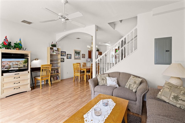 1149 S Beach Cir, Kissimmee, FL 34746 - living room featuring visible vents, arched walkways, electric panel, light wood-style floors, and ceiling fan with notable chandelier