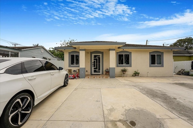 view of front facade featuring fence and stucco siding