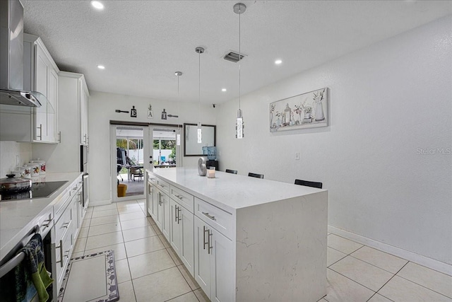 kitchen with visible vents, wall chimney exhaust hood, black electric stovetop, french doors, and a kitchen island