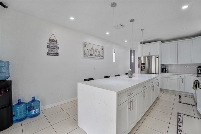 kitchen with stainless steel fridge with ice dispenser, light tile patterned floors, a center island, light countertops, and white cabinetry