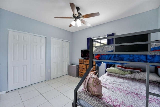 tiled bedroom with two closets and a ceiling fan