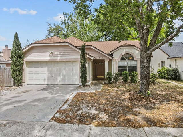1345 Tindaro Dr, Apopka, FL 32703 - view of front of property with driveway, stucco siding, roof with shingles, and an attached garage