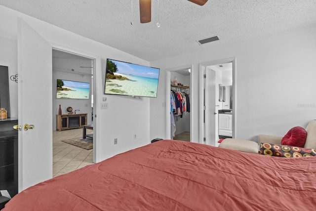 1345 Tindaro Dr, Apopka, FL 32703 - bedroom featuring a walk in closet, a textured ceiling, tile patterned floors, ensuite bath, and visible vents