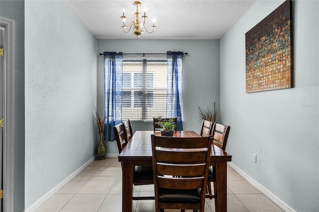 dining area with a textured wall, baseboards, a textured ceiling, light tile patterned flooring, and a notable chandelier