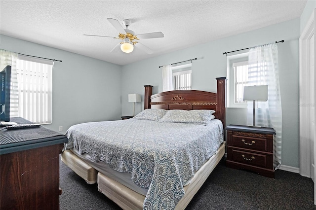 bedroom featuring a textured ceiling, ceiling fan, and dark colored carpet