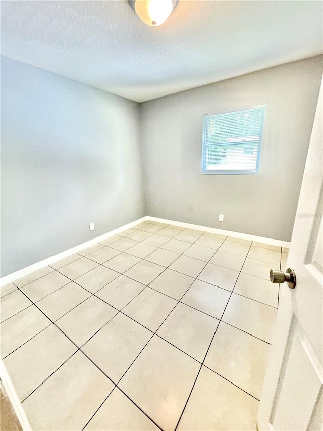 403 Terry St, Wildwood, FL 34785 - spare room with baseboards, light tile patterned floors, and a textured ceiling