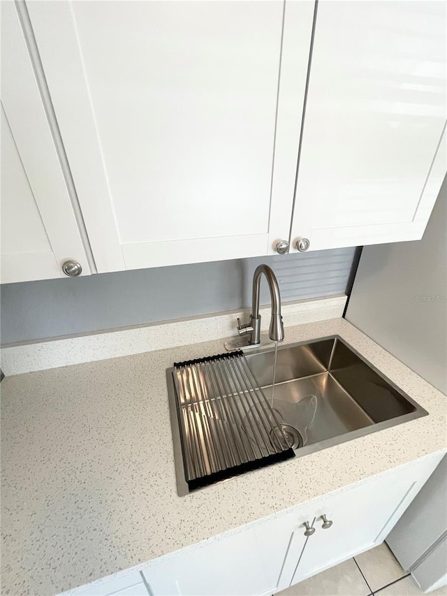 403 Terry St, Wildwood, FL 34785 - interior details featuring white cabinets, a sink, and light stone counters