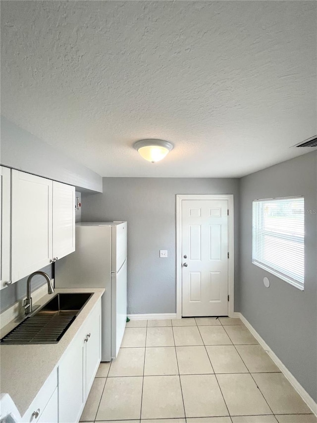 403 Terry St, Wildwood, FL 34785 - kitchen with light countertops, white cabinets, a sink, and visible vents