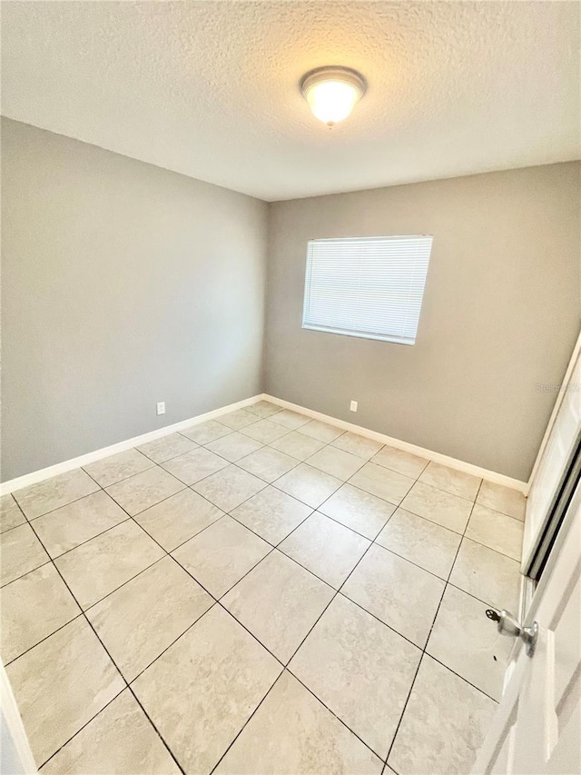 403 Terry St, Wildwood, FL 34785 - empty room with light tile patterned floors, baseboards, and a textured ceiling