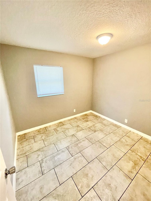 403 Terry St, Wildwood, FL 34785 - tiled empty room with baseboards and a textured ceiling