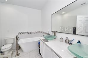 1237 Tallow Rd Unit 1237, Apopka, FL 32703 - full bath with a soaking tub, double vanity, toilet, and a sink