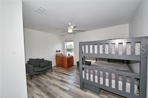 1237 Tallow Rd Unit 1237, Apopka, FL 32703 - bedroom featuring a ceiling fan, wood finished floors, and visible vents