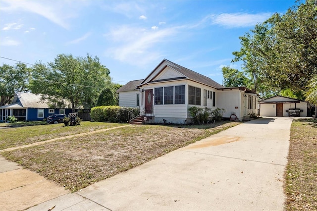 view of front of home with an outbuilding, a front yard, concrete driveway, and entry steps