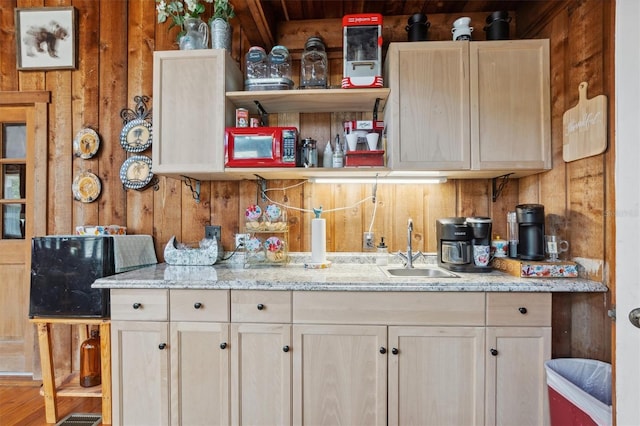 kitchen featuring a sink, wooden walls, and open shelves