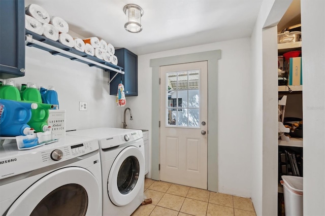clothes washing area with washing machine and clothes dryer, a sink, cabinet space, and light tile patterned floors