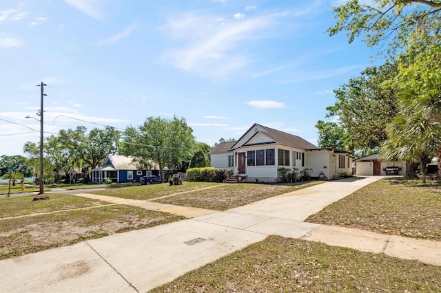 view of front of house with driveway, a front yard, an outbuilding, and a garage