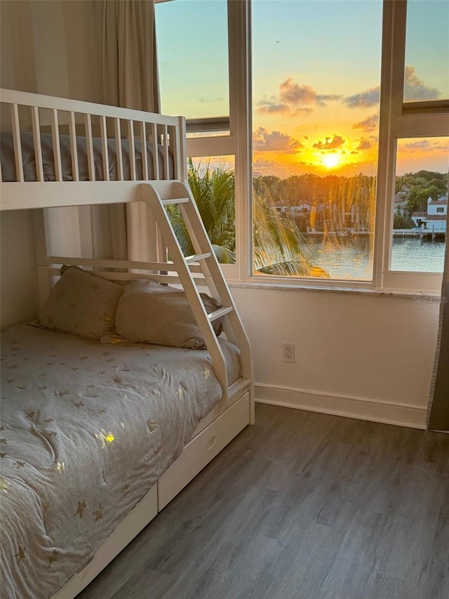 5600 Collins Ave Unit 6P, Miami Beach, FL 33140 - unfurnished bedroom with wood finished floors, multiple windows, and baseboards