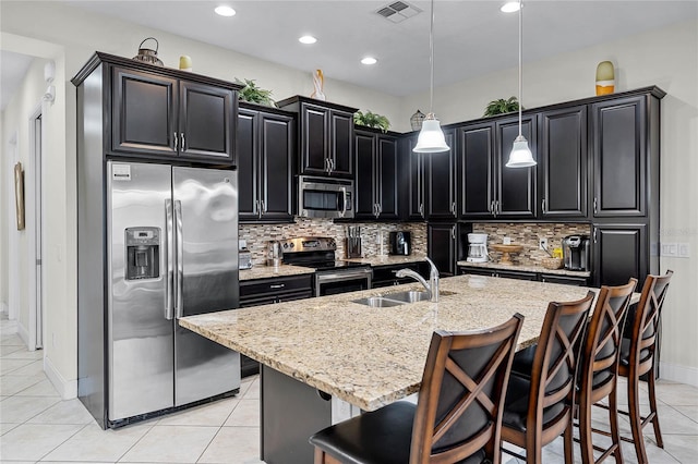 510 Captiva Dr, Davenport, FL 33896 - kitchen featuring a sink, dark cabinets, stainless steel appliances, visible vents, and decorative backsplash