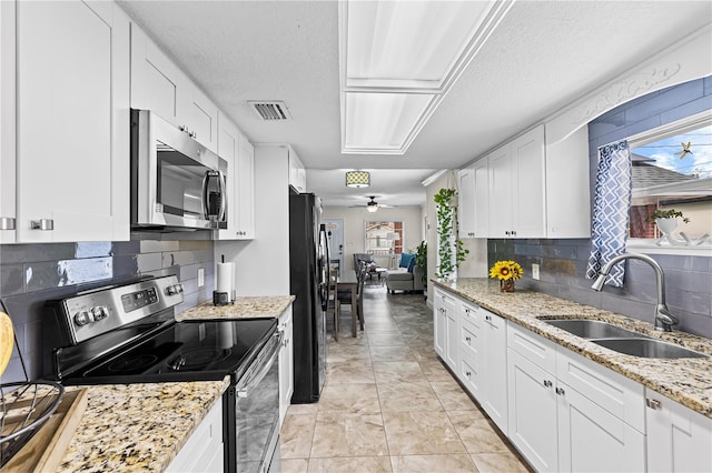 kitchen with white cabinets, visible vents, stainless steel appliances, a ceiling fan, and a sink