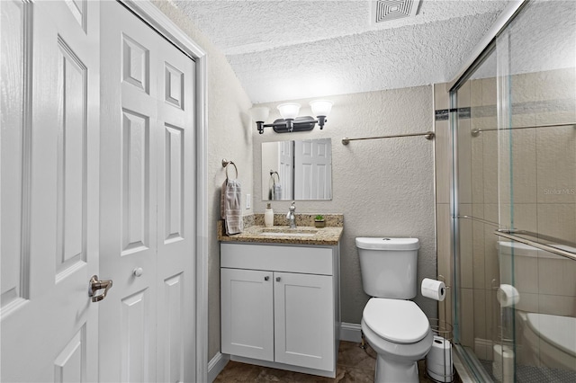 full bathroom with a stall shower, toilet, vanity, visible vents, and a textured wall