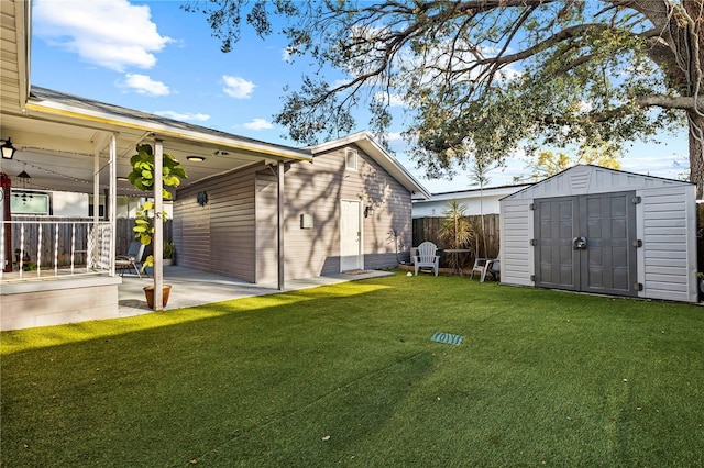 view of yard featuring an outdoor structure, a storage unit, fence, and a patio area