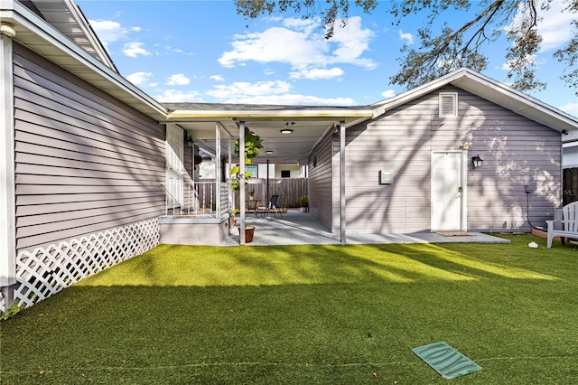 back of property with fence, a patio area, and a yard
