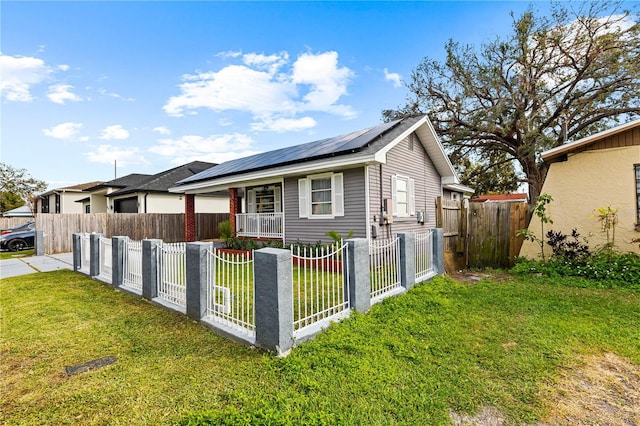 view of front facade featuring a gate, roof mounted solar panels, a front yard, a fenced front yard, and a porch