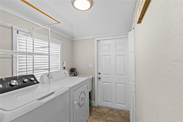 clothes washing area featuring a textured wall, independent washer and dryer, and laundry area