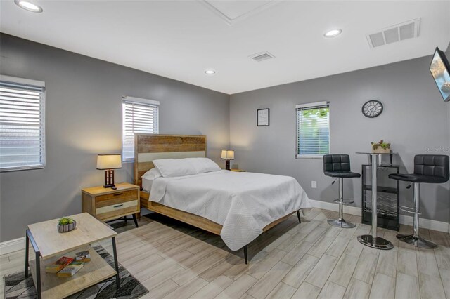 bedroom with baseboards, visible vents, and multiple windows