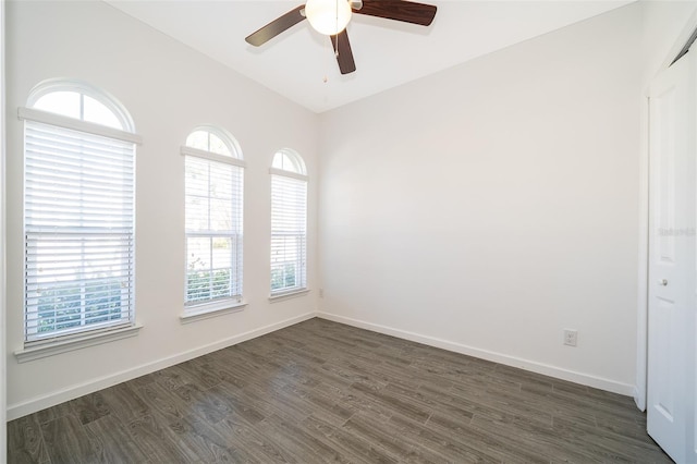 spare room featuring dark wood finished floors, baseboards, and ceiling fan