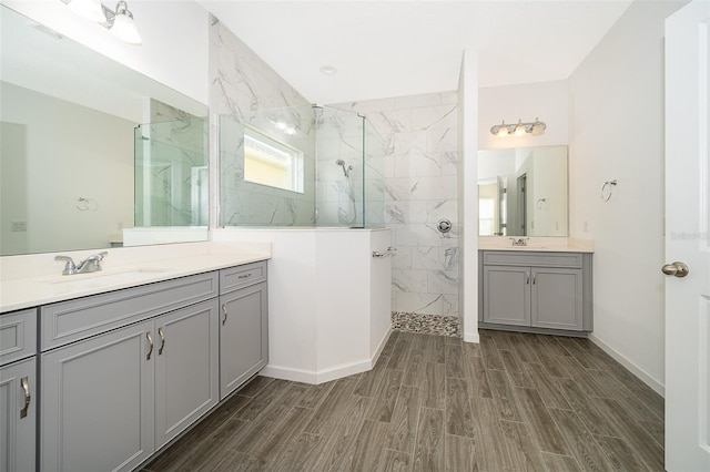 full bath with wood tiled floor, a sink, and a marble finish shower