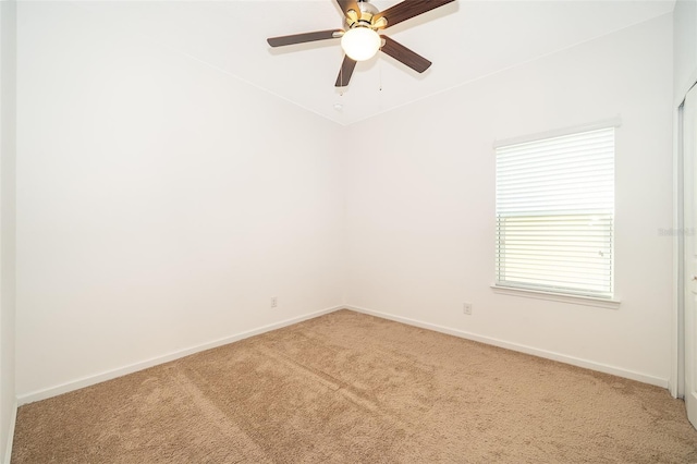 unfurnished room featuring baseboards, light colored carpet, and ceiling fan