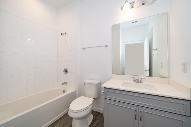 full bath with tub / shower combination, wood tiled floor, toilet, and vanity
