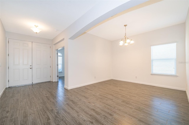 interior space with baseboards, dark wood-style flooring, a healthy amount of sunlight, and a chandelier