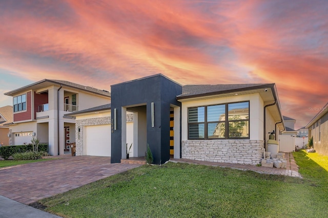2566 Trielle Ave, Kissimmee, FL 34741 - view of front facade featuring stone siding, a front yard, decorative driveway, and stucco siding