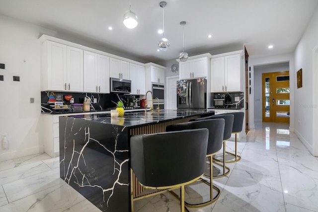 2566 Trielle Ave, Kissimmee, FL 34741 - kitchen featuring a kitchen island with sink, stainless steel appliances, marble finish floor, decorative backsplash, and recessed lighting