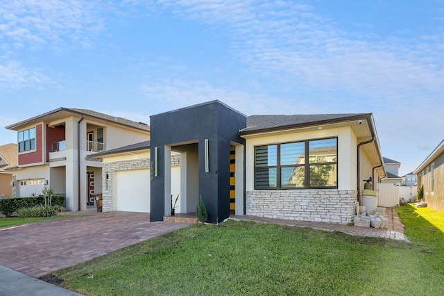 2566 Trielle Ave, Kissimmee, FL 34741 - view of front of house with a front lawn, decorative driveway, stone siding, and stucco siding