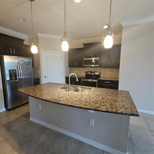 kitchen featuring crown molding, stainless steel appliances, dark stone countertops, a sink, and pendant lighting